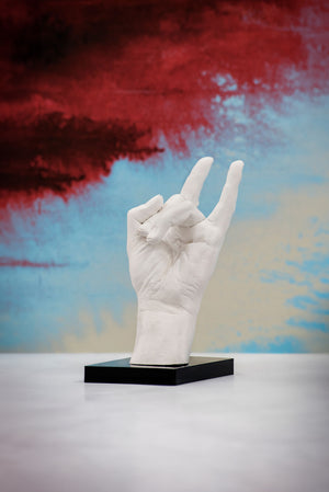 scultura di una mano con il gesto scaramantico delle corna